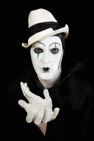 face and hands of mime with dark make-up on black backgroundの写真素材