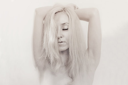 Studio portrait of a beautiful young woman with closed eyes and silver makeup on white backgroundの写真素材