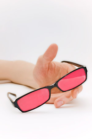 Human hand with pink glasses isolated on white backgroundの写真素材