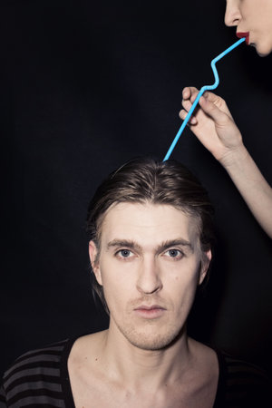 portrait of a young man and a woman with a cocktail strawの写真素材