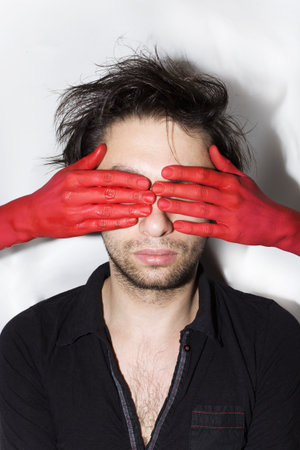 male face with eyes closed women's red handsの写真素材