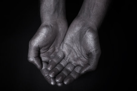 Two hands folded a handful on a black backgroundの写真素材