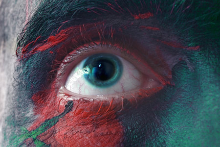 Male blue eyes bright with war paint macroの写真素材