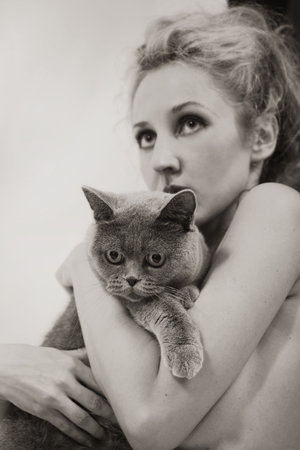 Young beautiful woman with a gray British cat in the handsの写真素材