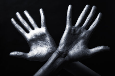 Men's hand in a silver paint isolated on black background
の写真素材