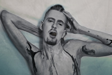 Portrait of a young man in the theatrical make-up with his tongueの写真素材