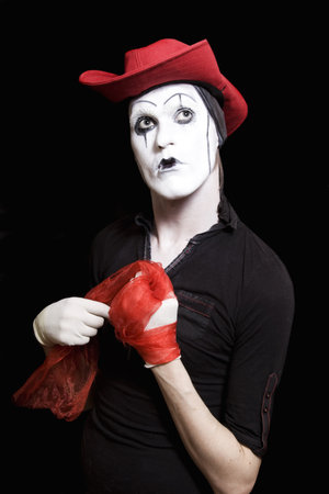 Mime in a red cowboy hat on a black backgroundの写真素材