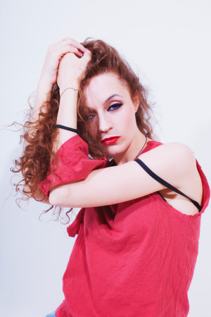 	beautiful curly brunette woman in red T-shirt  on white backgrounの写真素材