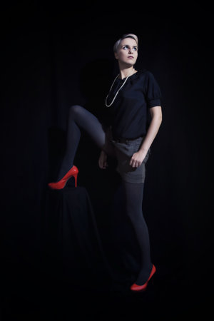 Beautiful young woman with short hair standing on black backgroundの写真素材