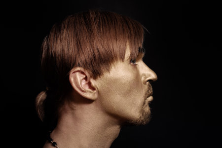 Portrait of young handsome  men with gold makeup and red hairの写真素材
