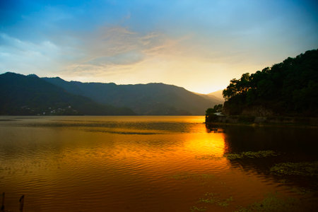 Evening landscape with lake and mountains in Pokhara, Nepalの写真素材