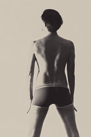Young beautiful naked man light backgroundの写真素材
