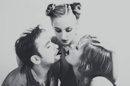 Two women and one man with the red ripe cherries close upの写真素材