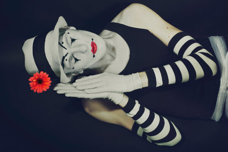 sleep mime in white hat with red flower on a black backgroundの写真素材