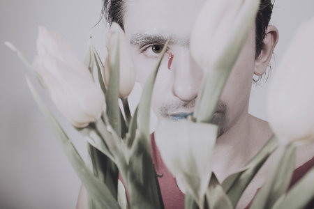 Face of young man with flower on white backgroundの写真素材