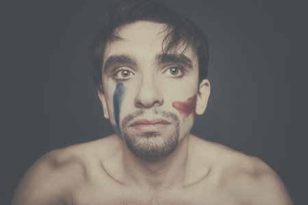 Portrait of beautiful young man with paint on his faceの写真素材