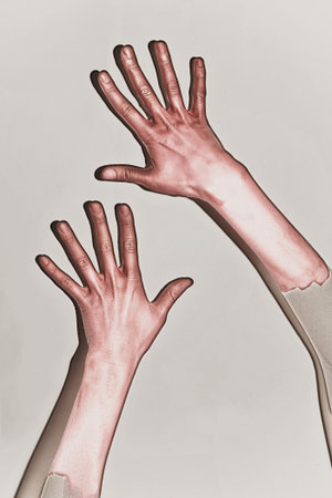 Male hands painted in red paint on a white backgroundの写真素材