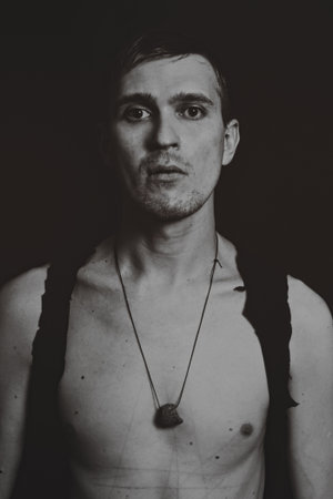 Studio portrait of a young man on a black backgroundの写真素材