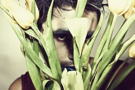 Face of young man with flower on white backgroundの写真素材