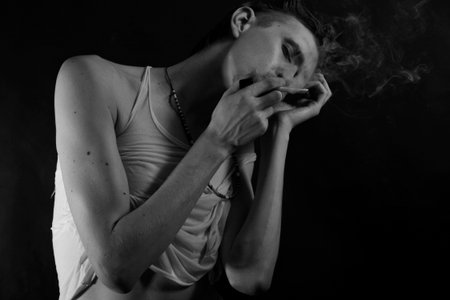 monochrome portrait of a young male smokers in smokeの写真素材