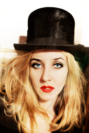 Portrait of  beautiful young woman dressed in black top-hatの写真素材