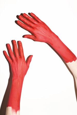 Male hands painted in red paint on a white background