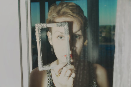 Portrait of beautiful young woman behind transparent glass