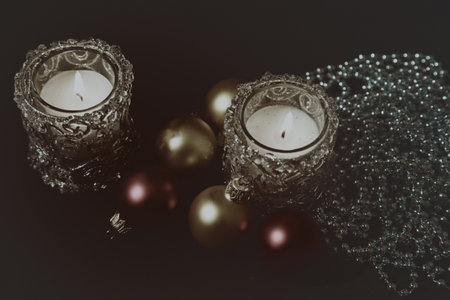 Christmas greeting card with candles and Christmas decorations on a black background