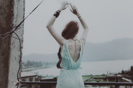 Young beautiful woman dancing on the roofの写真素材