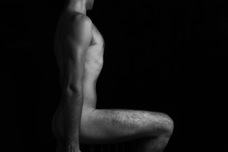 Beautiful naked male body on black backgroundの写真素材