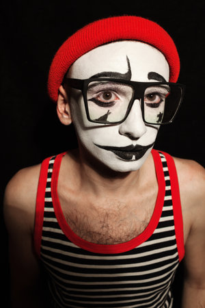 Portrait of sad mime wearing eyeglasses on black backgroundの写真素材
