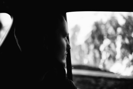 Portrait of man looking out the car windowの写真素材