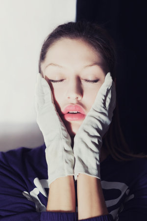 Portrait of beautiful young girl wearing white glovesの写真素材