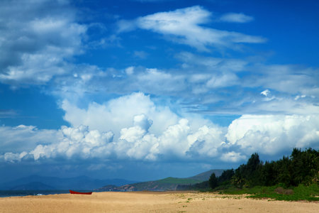 Landscape with sea, mountains, dramatic sky and red boat on the shoreの写真素材