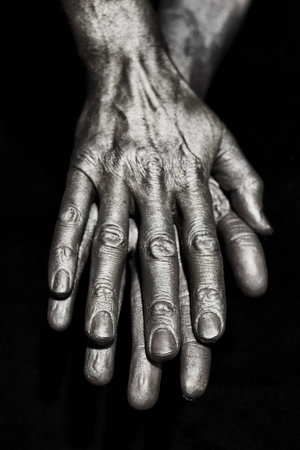 Sculptural Metal male hands on a black backgroundの写真素材