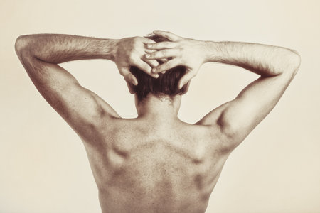 Studio photography of naked back of young man on white backgroundの写真素材