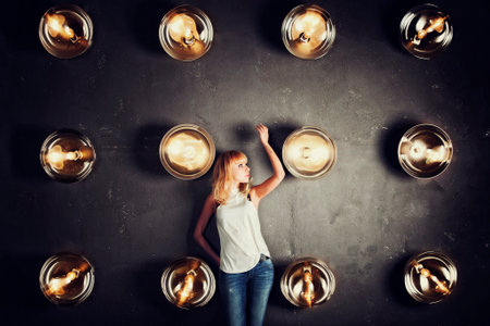Girl model standing against the wall with spotlights in photo studioの写真素材