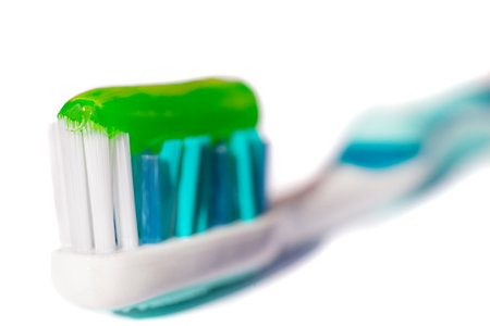 Blue toothbrush with green toothpaste isolated on a white backgroundの写真素材