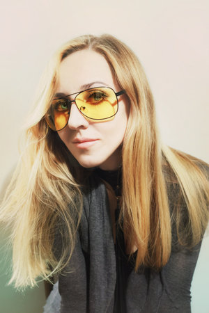 Portrait of woman wearing a yellow sunglasses on white backgroundの写真素材