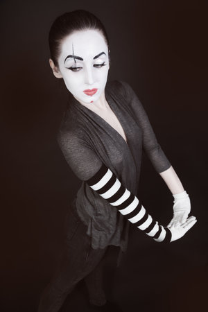 female mime in  gray jacket on  black backgroundの写真素材