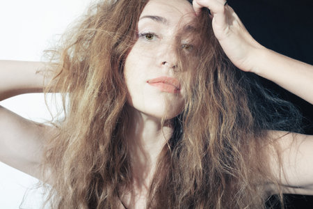 Portrait of a beautiful young woman with long curly hairの写真素材