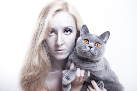 Portrait of a young woman with a gray British catの写真素材