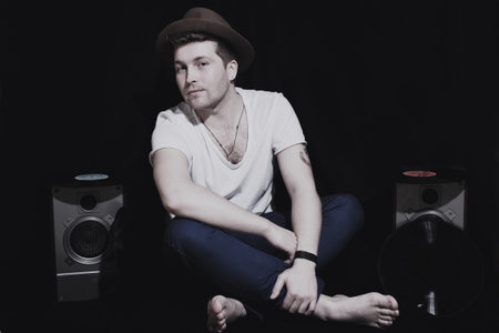 Portrait of a young man wearing a hat with a music equipment