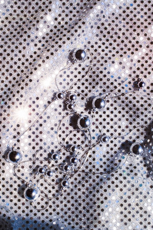 Silver beads on shiny bright cloth mirrorsの写真素材