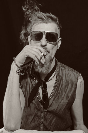 Portrait of young man with cigarette wearing a sunglassesの写真素材