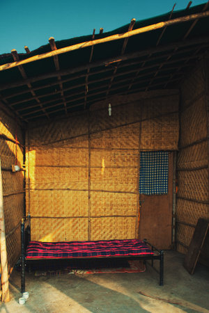 Dilapidated housing with a bed in the slums of Indiaの写真素材