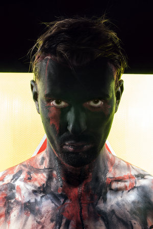 Portrait of man with black face and sullen look