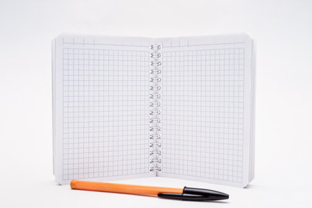 Open notebook and ball pen on a white backgroundの写真素材