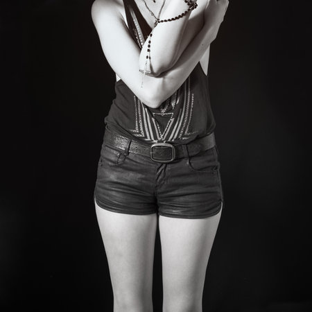A young girl dressed in leather shorts with a belt and a vest. Rock styleの写真素材