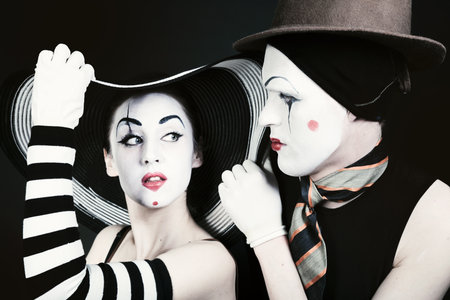 Portrait of two flirting mimes on a black background. Theatrical Performanceの写真素材